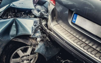 After a car accident, a silver vehicle with a European license plate shows significant damage to its rear, while the other car’s front end is also badly wrecked.