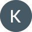 A gray circle with a white letter "K" centered inside on a dark gray background, inspired by Carrel Taylor’s minimalist design style.