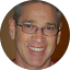 Daniel Robinson, a person with short gray hair and glasses, is smiling in a circular cropped photo.